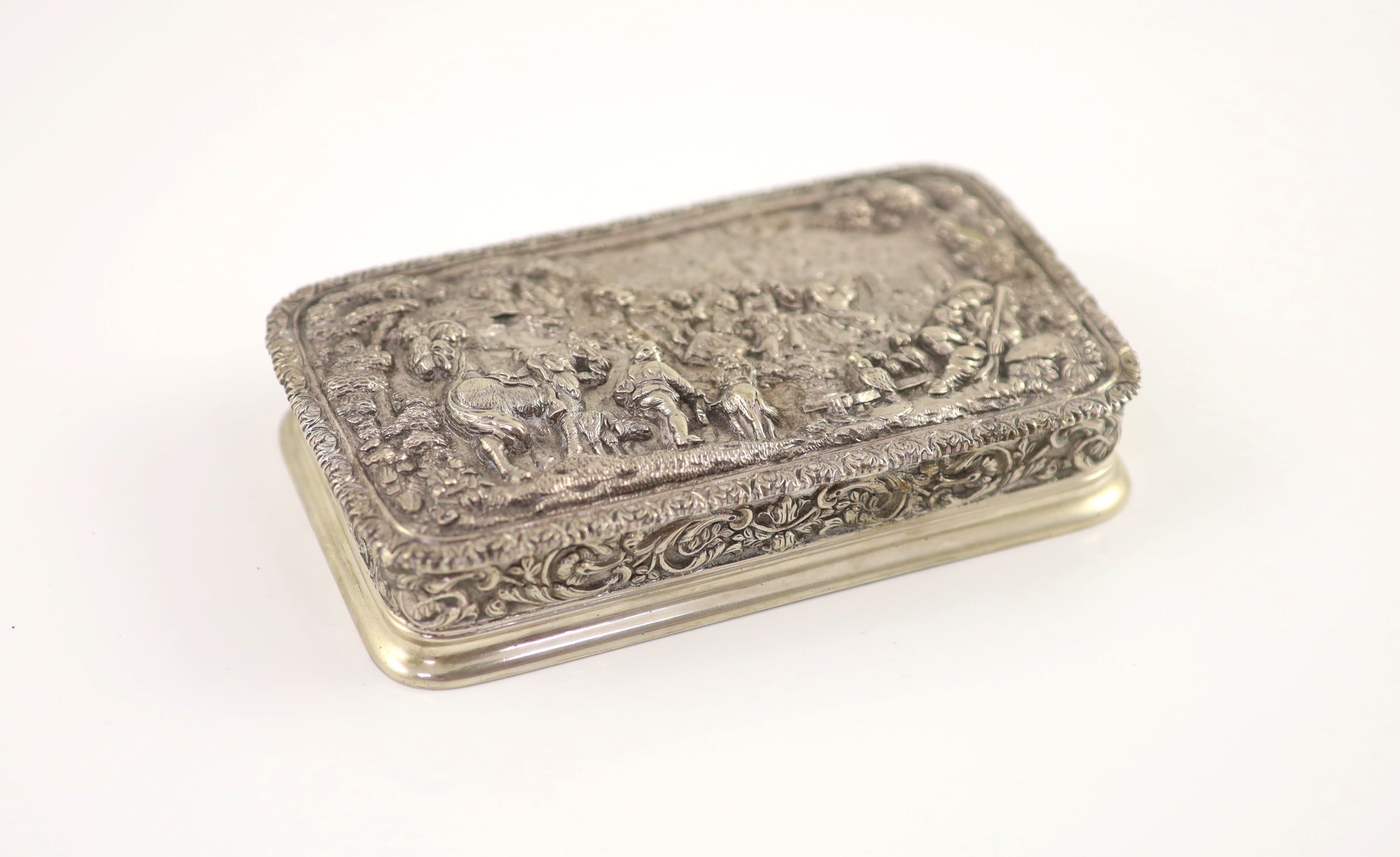 A 20th century Portuguese 833 standard silver rectangular box and cover, the lid cast and chased in high relief with travellers approaching a town,